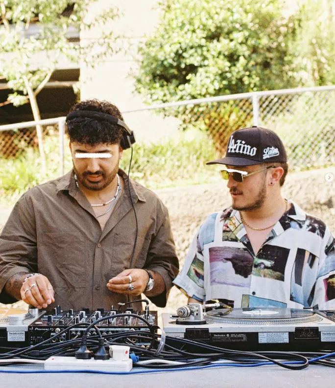 Two DJs playing vinyl outdoors